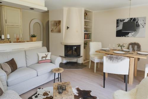 a living room with a white couch and a fireplace at Willkommen in Ihrem sonnigen Gartenapartment in Kitzbühel