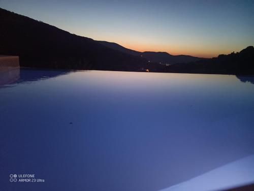 a large body of water with the sunset in the background at Celini villa Tinos in Krokos