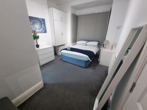 a small bedroom with a bed and white cabinets at Generous double bedroom with ensuite - home from home! in Birmingham