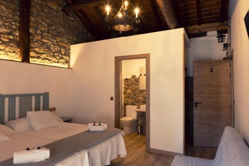 a bedroom with two beds and a door to a bathroom at Hospedería La Bogadera in La Robla