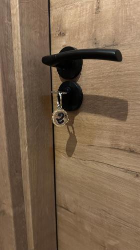 a black door handle with a key on a wooden door at Hospedería La Bogadera in La Robla