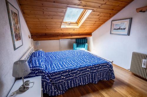 a bed in a room with a wooden ceiling at Antica Rosa - Mansarda vista montagna con posto auto scoperto in Fiera di Primiero