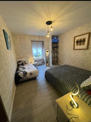 a bedroom with two beds and a table and a television at Gite la Vieille Auberge de Chaumard in Chaumard