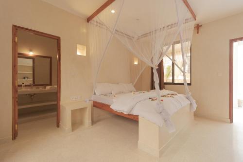 een slaapkamer met een bed met een klamboe bij Tawi Elegant Rooms - Watamu in Watamu