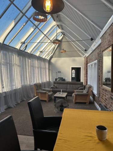 a living room with couches and tables and a glass ceiling at Castle View in Hastings