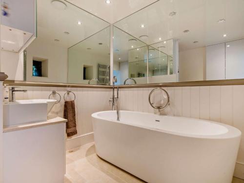 a bathroom with a tub and a large mirror at 6 Bed in Martindale 95344 in Patterdale