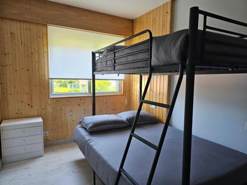 a bedroom with two bunk beds in a room with a window at Apartamento Playa de Ber in Puentedeume