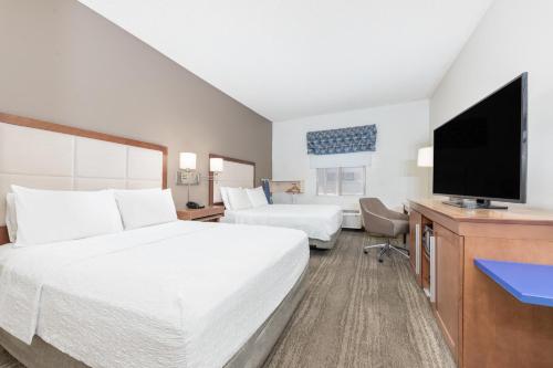 a hotel room with a bed and a flat screen tv at Hampton Inn Phoenix Midtown Downtown Area in Phoenix