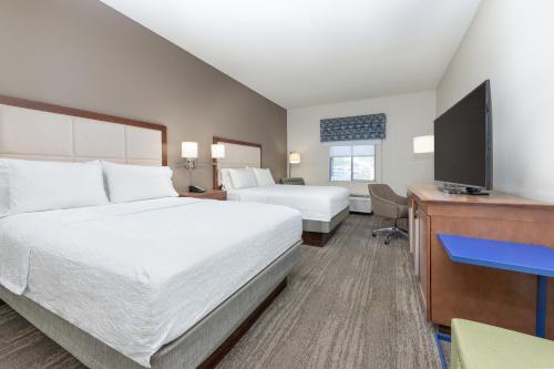 a hotel room with two beds and a flat screen tv at Hampton Inn Phoenix Midtown Downtown Area in Phoenix