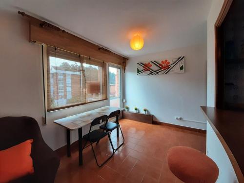 a living room with a table and a window at Apartamento Playa de Ber in Puentedeume