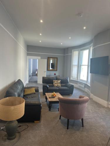 a living room with a leather couch and a table at Castle View in Hastings
