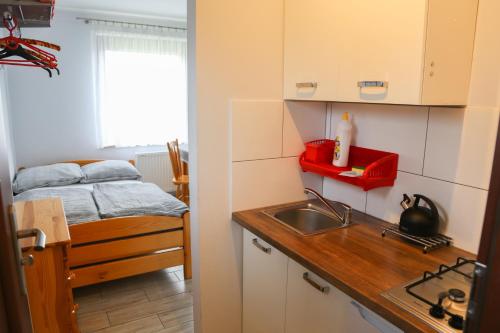 cocina pequeña con fregadero y cama en Pokoje u SŁONIA, en Stegna