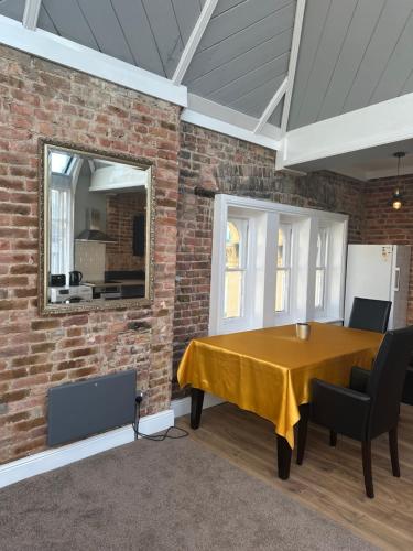 a dining room with a brick wall and a table and chairs at Castle View in Hastings