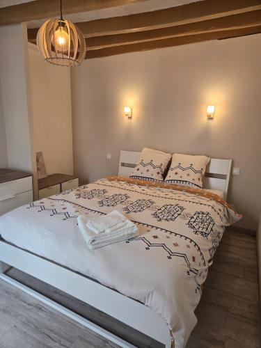 a bedroom with a large white bed with pillows at Maison de ville spacieuse in Valençay