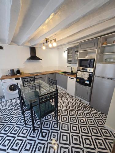 a kitchen with a table on a geometric floor at Maison de ville spacieuse in Valençay