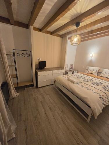 a bedroom with a bed and a desk and a television at Maison de ville spacieuse in Valençay