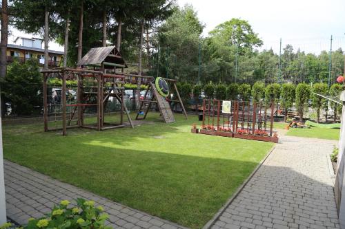 un parque con parque infantil y equipo de juegos en Pokoje u SŁONIA, en Stegna