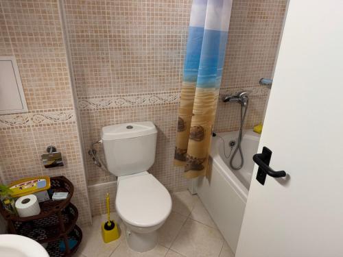 a bathroom with a toilet and a tub and a sink at Central Plaza Apartment in Sunny Beach