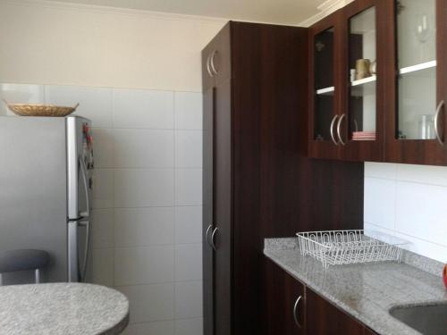 eine Küche mit einem Kühlschrank und einer Arbeitsplatte in der Unterkunft Departamento en Condominio Mar Serena in La Serena