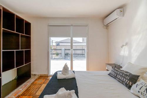 Un dormitorio con una cama y una ventana grande. en Alojamiento temporal La Josefina, en Tandil