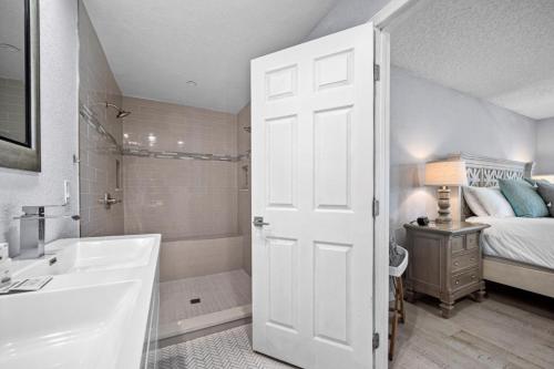 a bathroom with a white door and a bed and a tub at Canal Front Beach Home, Private Pool in Flagler Beach