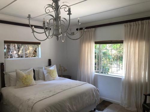 a bedroom with a bed and a chandelier at Beachfront petfriendly cottage in Zinkwazi Beach