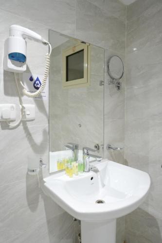 a bathroom with a white sink and a mirror at Afaq Al Marsa For Furnished Apartments in Medina