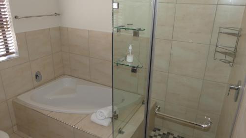 un baño con ducha y bañera en Oyster Catcher Stay And Explore, en Cape St. Francis