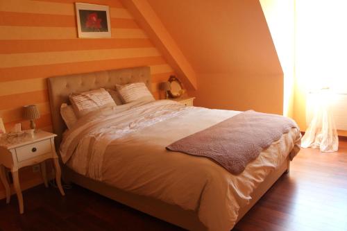 une chambre avec un lit et une table avec une lampe dans l'établissement Le Clos Des Roses, à Saint-Règle