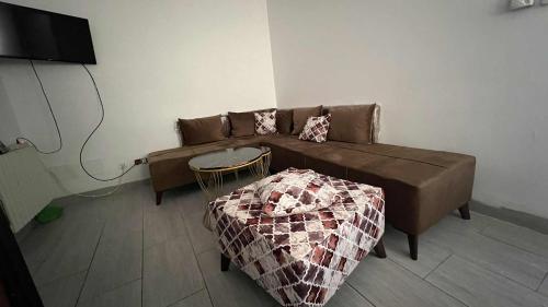 a living room with a brown couch and a table at Residence Golden Beach in Bin Rhilouf