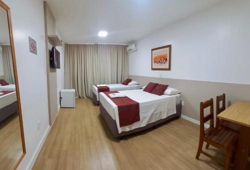 a hotel room with two beds and a table at Max Hotel in Brasilia