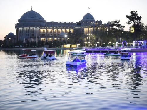 a group of boats in the water in front of a building at Al-Beruni 4 in Dushanbe