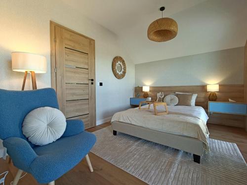 a bedroom with a bed and a blue chair at Na Pokładzie e-apart in Jastrzębia Góra