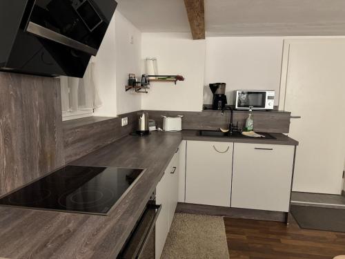 a kitchen with white cabinets and a black counter top at Haus Monika - wunderschöne ruhige Wohnung in Fürstenfeldbruck