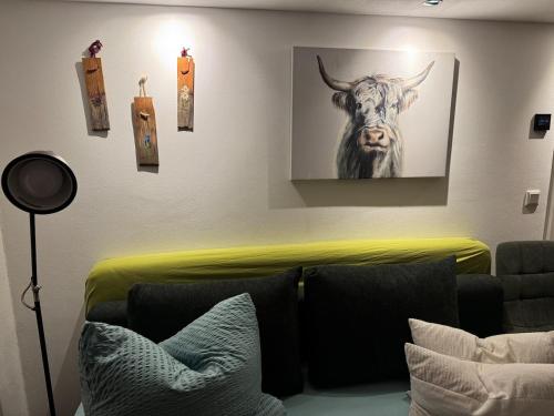 a living room with a picture of a cow on the wall at Haus Monika - wunderschöne ruhige Wohnung in Fürstenfeldbruck