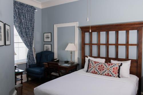 a bedroom with a bed and a desk and a chair at The Marshall House, Historic Inns of Savannah Collection in Savannah