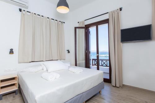 a bedroom with a bed and a balcony at Amalthia Luxury Studios in Naxos Chora