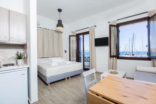 a room with a bed and a kitchen with a table at Amalthia Luxury Studios in Naxos Chora