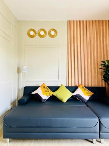 a blue couch with pillows on it in a room at Chic 1-Bedroom Hideaway in Ligao City, Albay in Tuburan