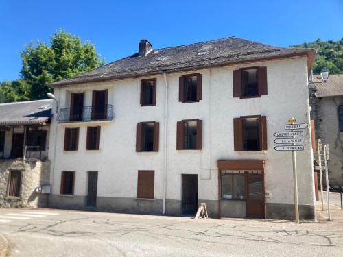 an old white building with a street sign in front of it at Pyrenean Pursuits in Biert
