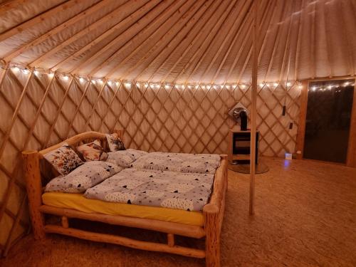 a bedroom with a bed in a tent at 02 JURTA hnědá v jablečném sadu 