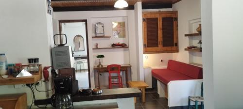 a living room with a red couch and a table at Agrikia House fully renovated peaceful 1km from Plakias beach in Plakias