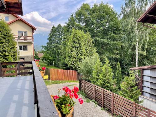 a balcony with a fence and flowers in a yard at Casa Zena Predeluț in Predeluţ