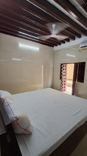 a bedroom with a large white bed with a window at The Imperial Regency in Porbandar