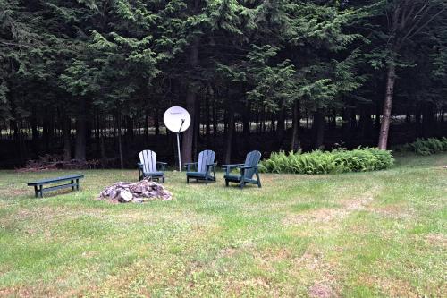 two chairs and a table in a field with a satellite at Mooseleuk Lodge in The Highlands