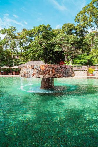 a fountain in the water in a swimming pool at Rio Quente Resorts - Hotel Giardino in Rio Quente