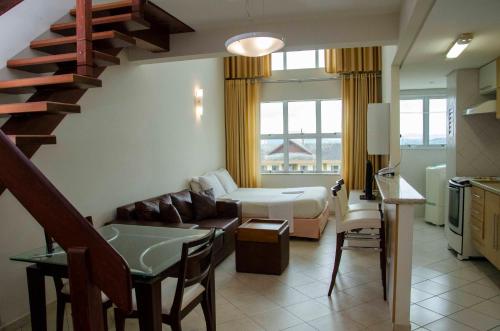 a living room with a couch and a bed and a staircase at Hotel City Hall in São José dos Campos