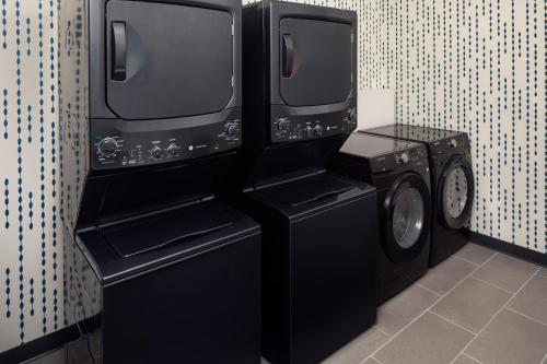 two washer and dryers in a laundry room at Home2 Suites By Hilton Clearwater St. Petersburg Ulmerton Rd in Clearwater