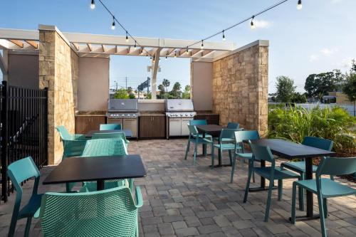 a patio with tables and chairs and a kitchen at Home2 Suites By Hilton Clearwater St. Petersburg Ulmerton Rd in Clearwater