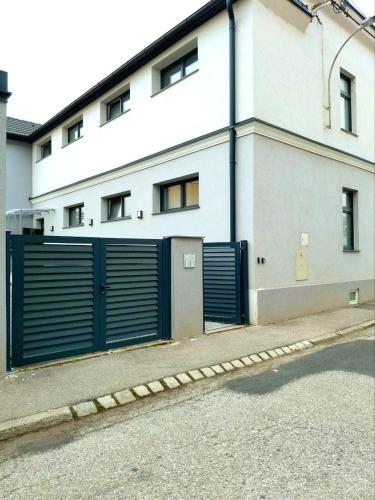 a white building with a blue garage door at Family Design Apartments 2 rooms Neunkirchen 3 in Neunkirchen